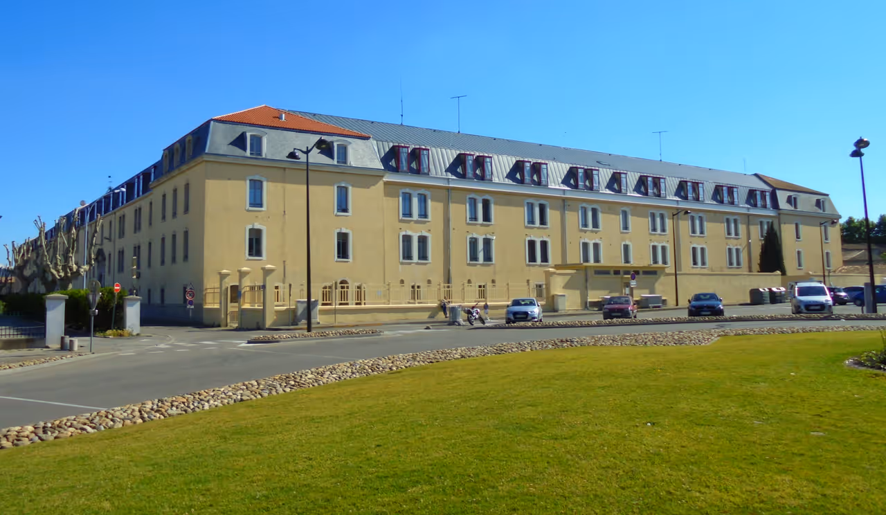 Caserne Laperrine historic military barracks in Carcassonne with blue sky and green lawn