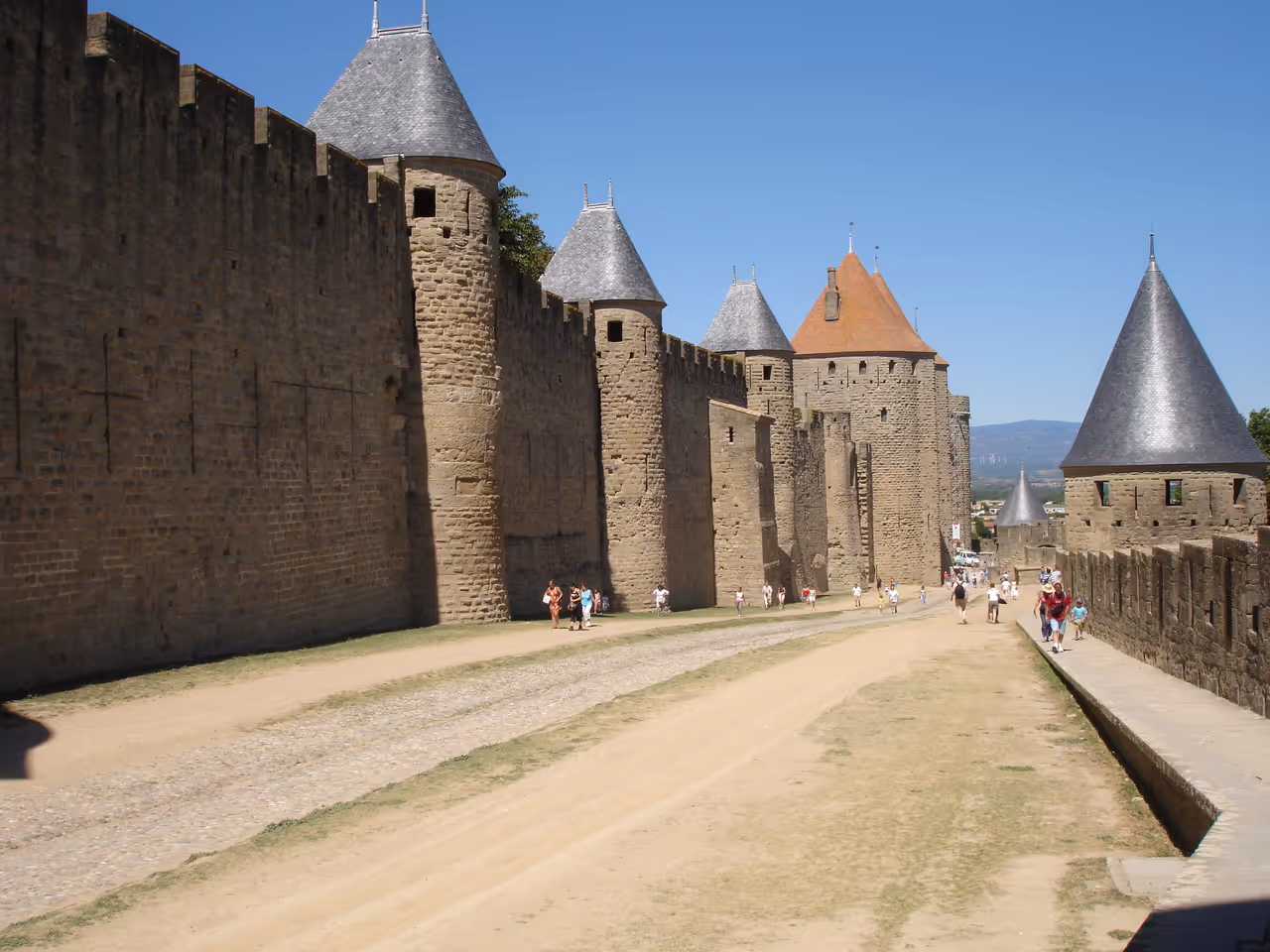 Medieval stone fortress walls and towers of the historic fortified city of Carcassonne under a clear blue sky