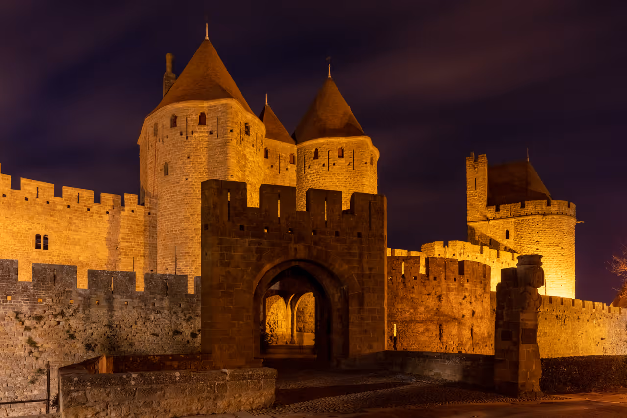 Illuminated medieval stone walls and towers of the fortified city of Carcassonne at night
