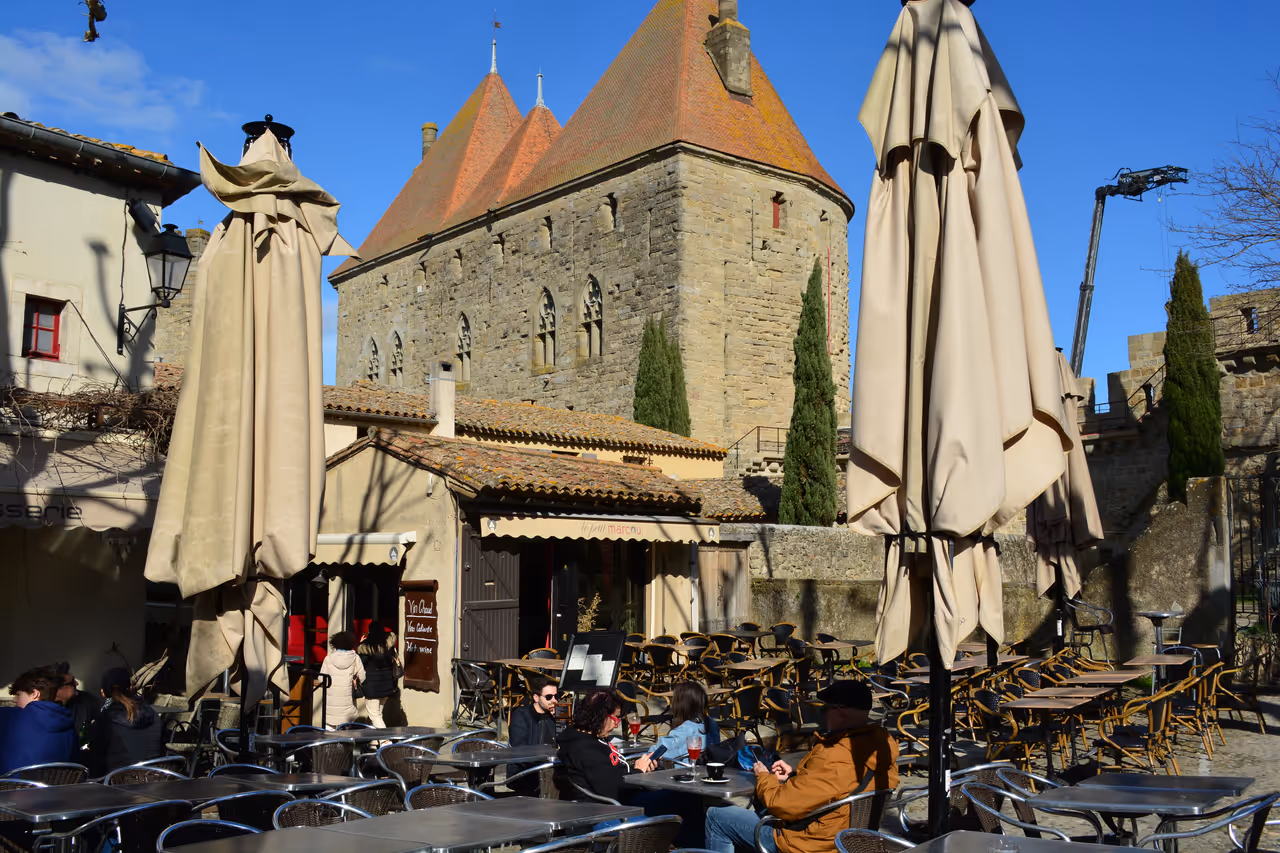 Outdoor cafe tables and folded umbrellas in Place Marcou in the historic fortified city of Carcassonne