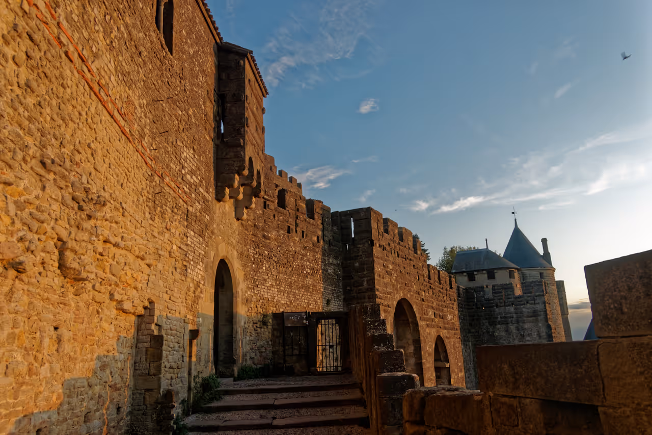 View south of Porte d'Aude at the medieval Cité de Carcassonne, showing grey stone walls restored by Eugène Viollet-le-Duc