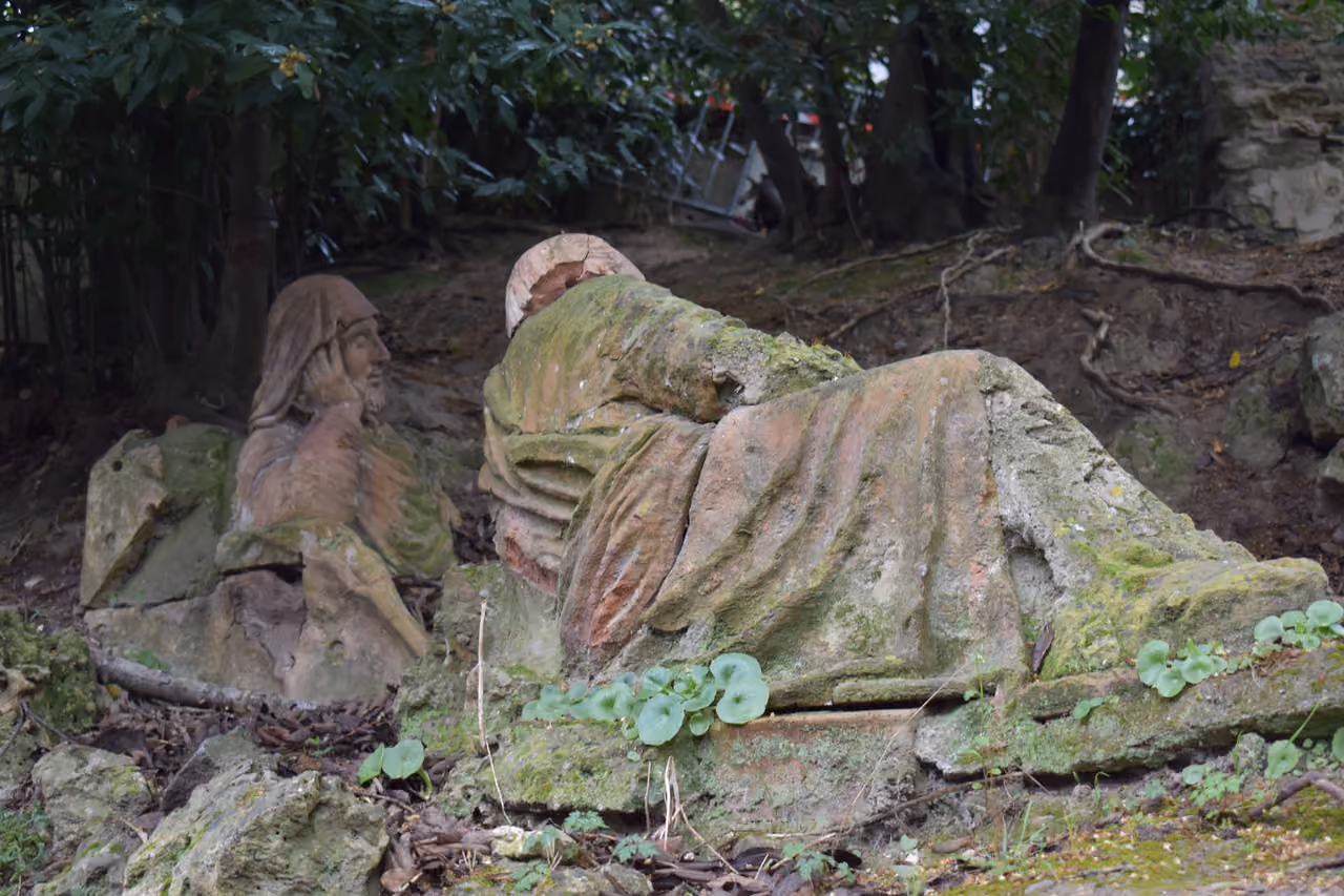 Moss-covered stone statues in the Jardin du Calvaire de Carcassonne garden