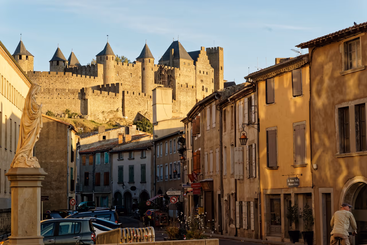 View of historic stone fortress towers and traditional buildings on Rue Trivalle in Carcassonne