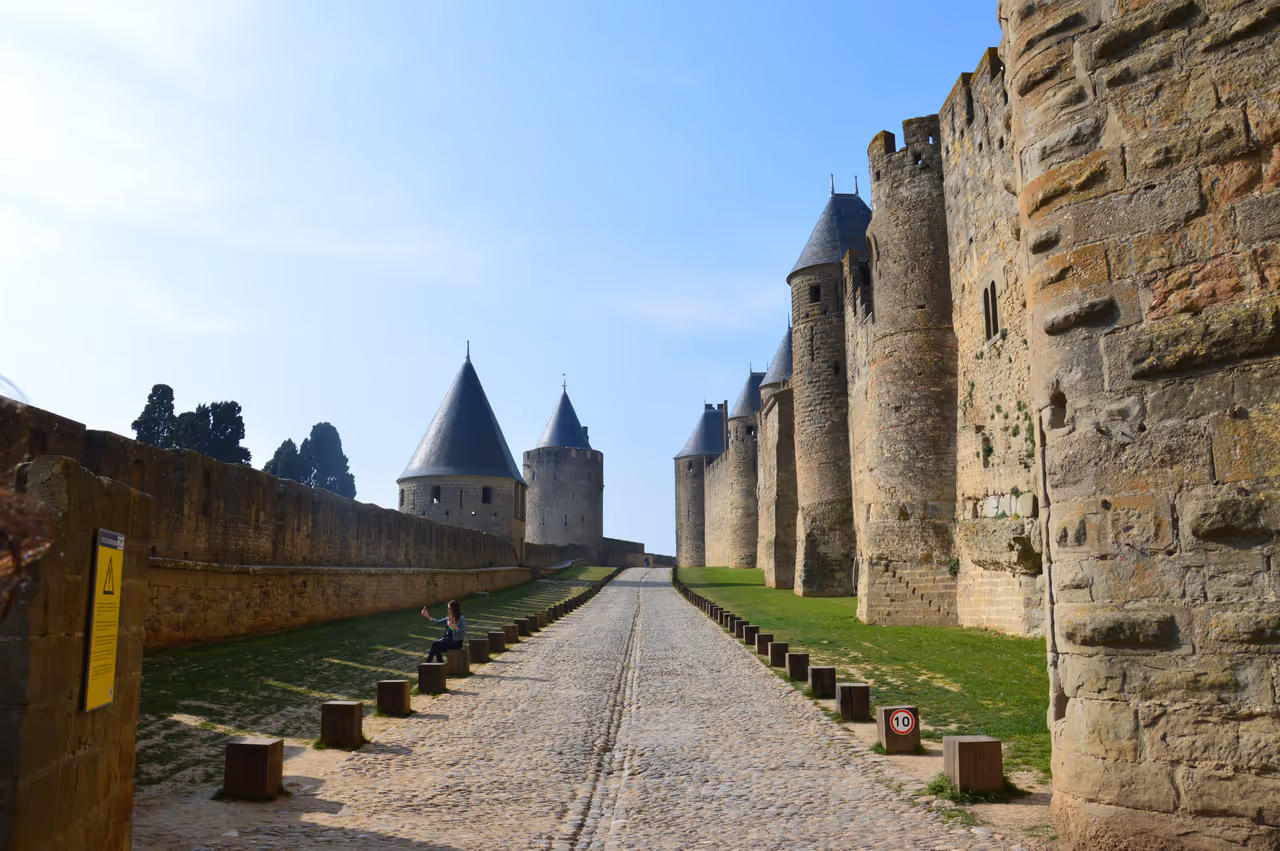 Cobblestone path between the medieval stone walls and towers of Carcassonne Citadel