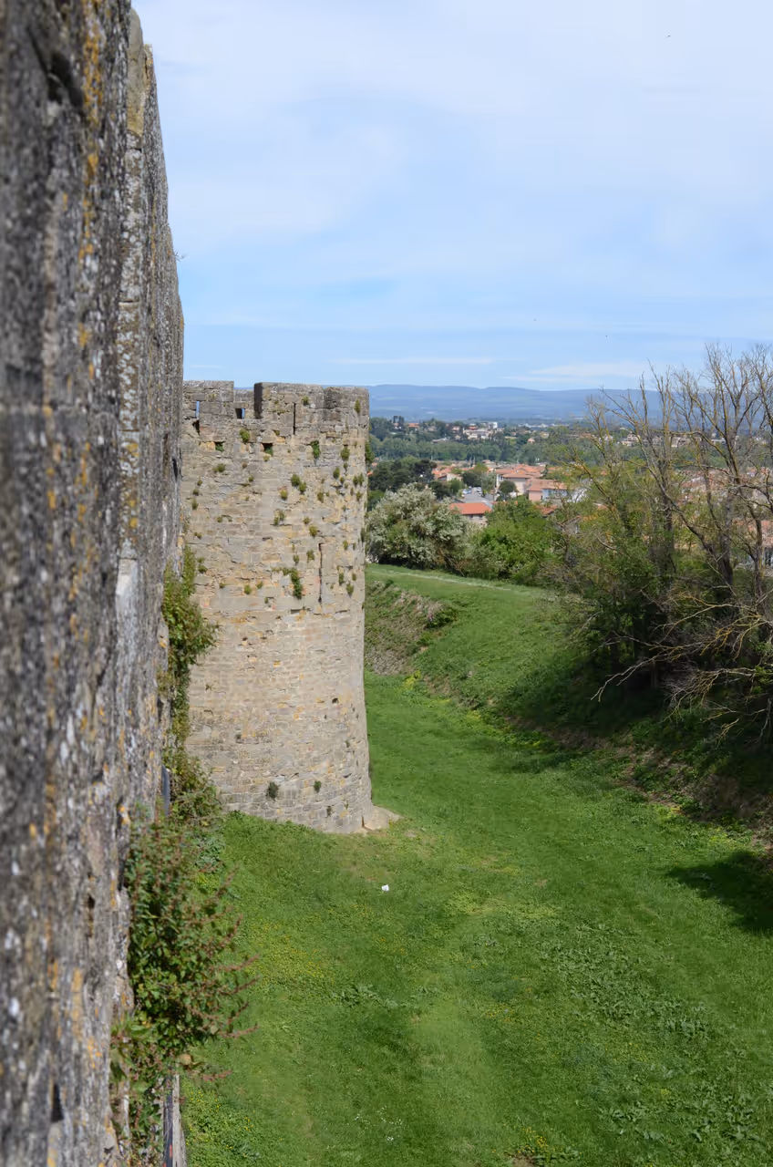 Medieval stone fortifications and defensive tower of the fortified city of Carcassonne seen from the ramparts