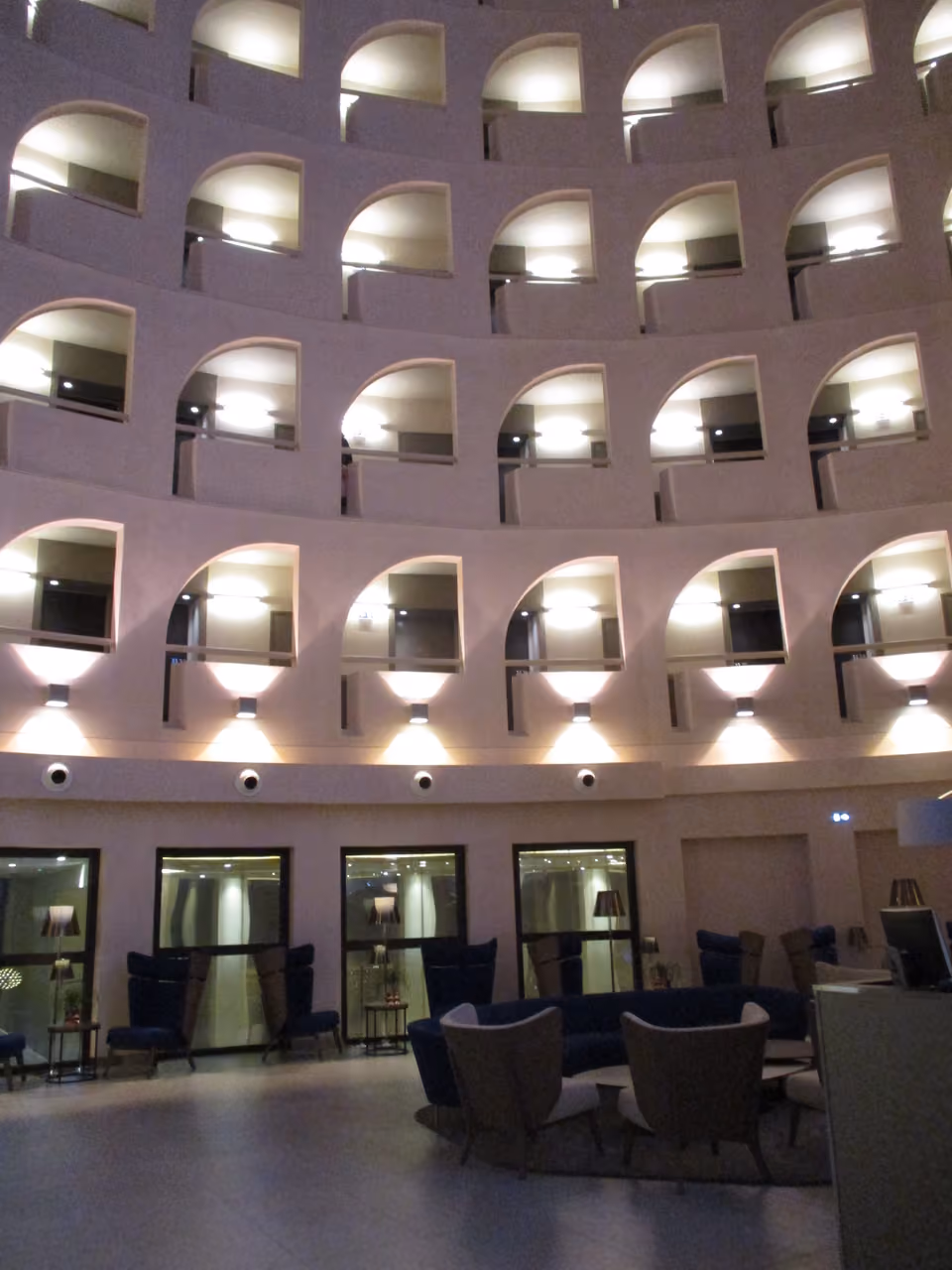 Modern atrium interior of Celest Bar and Restaurant at Radisson Blu Hotel Lyon with arched windows and lounge seating at night