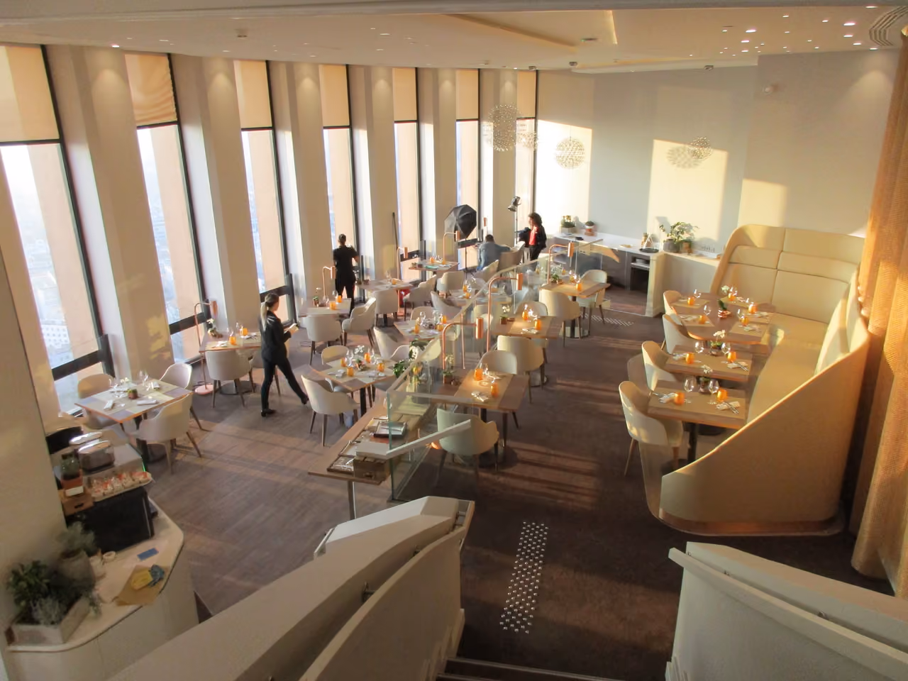 High-angle view of the elegant Celest Bar and Restaurant interior at the top of the Part-Dieu Tower featuring modern seating and floor-to-ceiling windows with panoramic city views