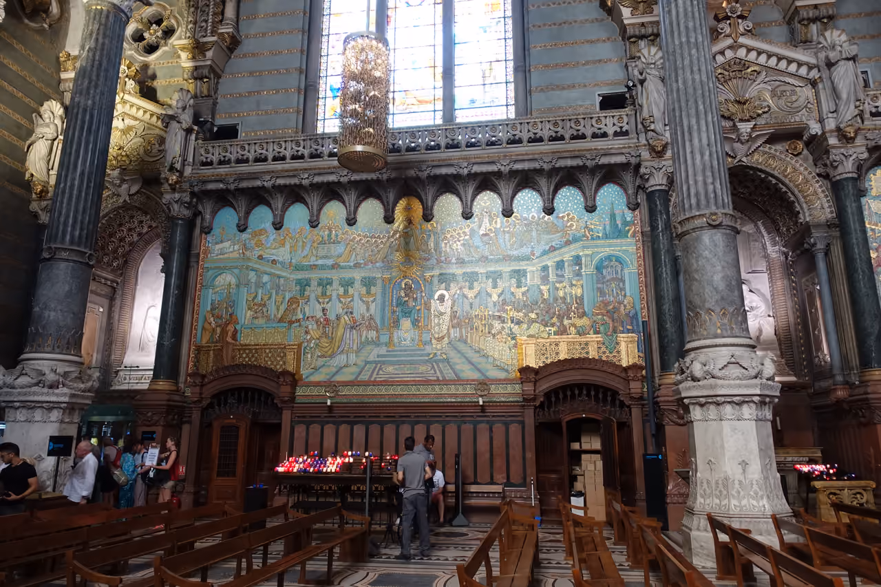 Interior of Basilique Notre-Dame de Fourvière showing ornate mosaic wall art and columns