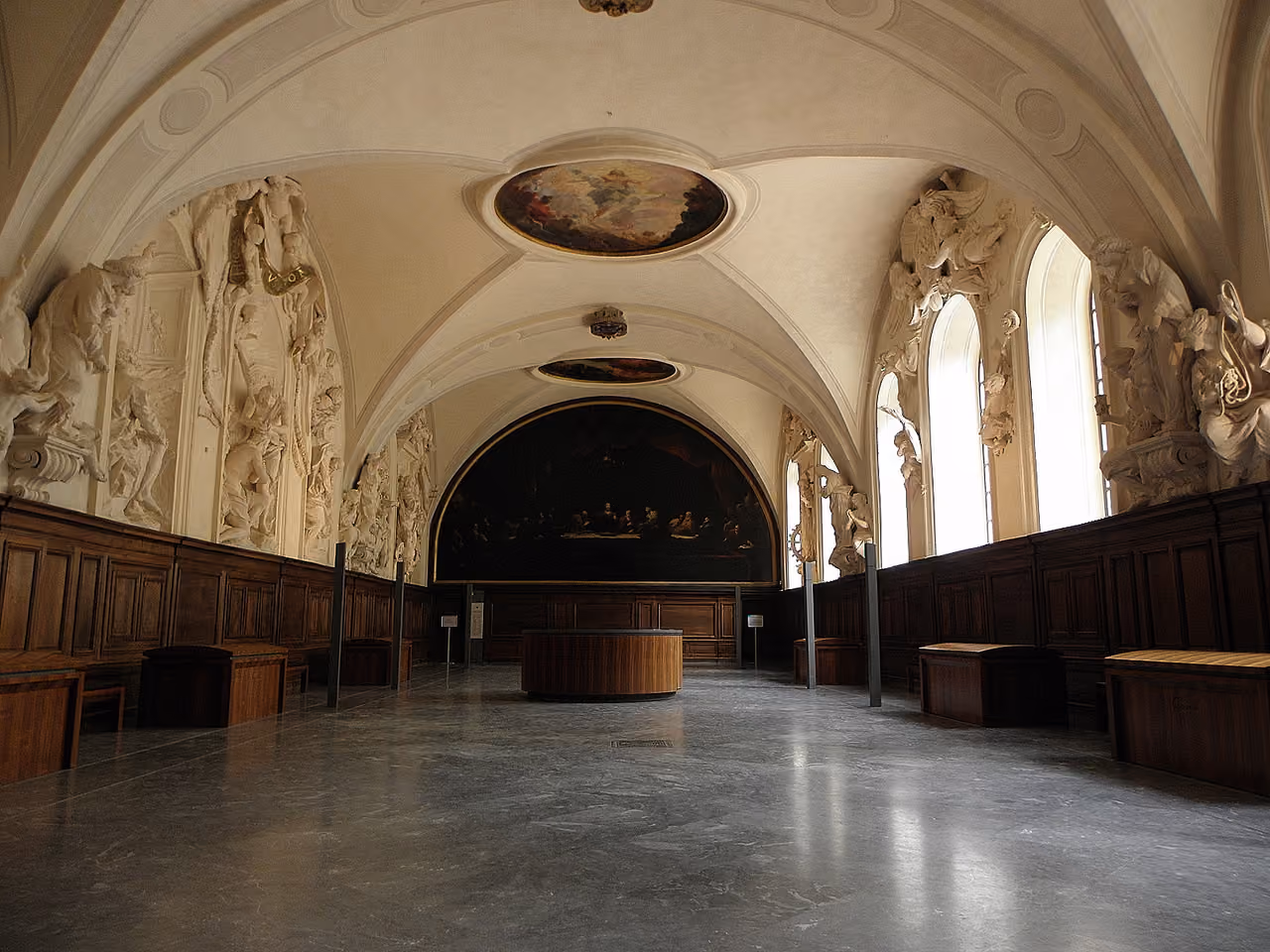 The historic refectory of the Palais Saint-Pierre featuring ornate baroque sculptures, wood panelling and a vaulted ceiling painting