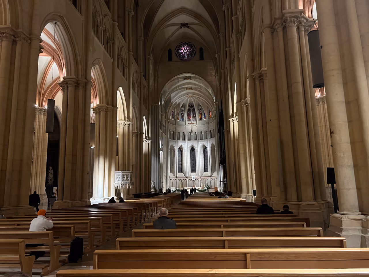 Interior of the Lyon Cathedral with rows of wooden pews leading toward the altar and Gothic arches
