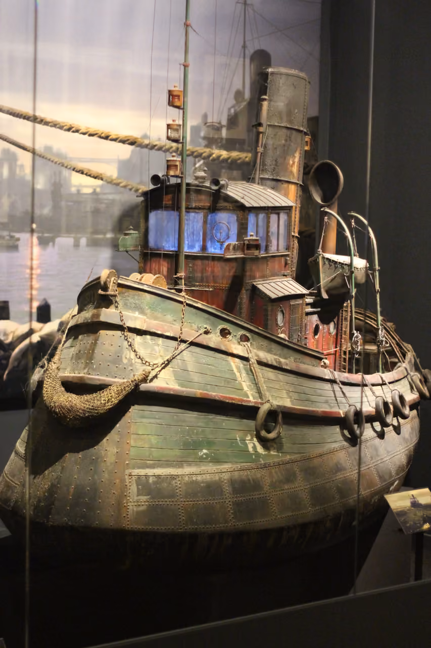 A detailed miniature model of the weathered steampunk style tugboat prop from the French film The City of Lost Children on display at the Musée Miniature et Cinéma in Lyon