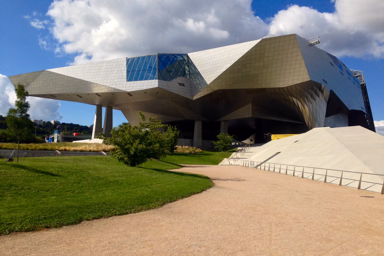 Modern futuristic architecture of the Musee des Confluences with metallic geometric facets under a blue sky
