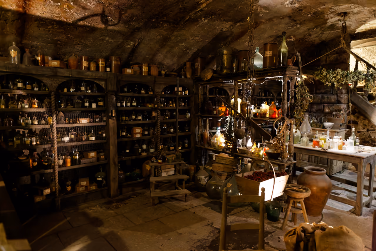 An authentic film set miniature of a historic perfume laboratory with glass bottles on wooden shelves at the Musee Miniature et Cinema