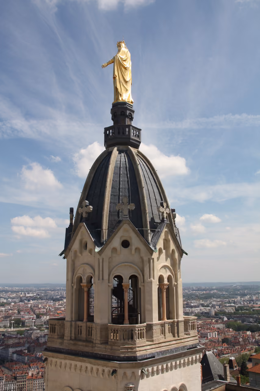 Golden statue of the Virgin Mary on top of the bell tower dome of Notre-Dame de Fourviere basilica