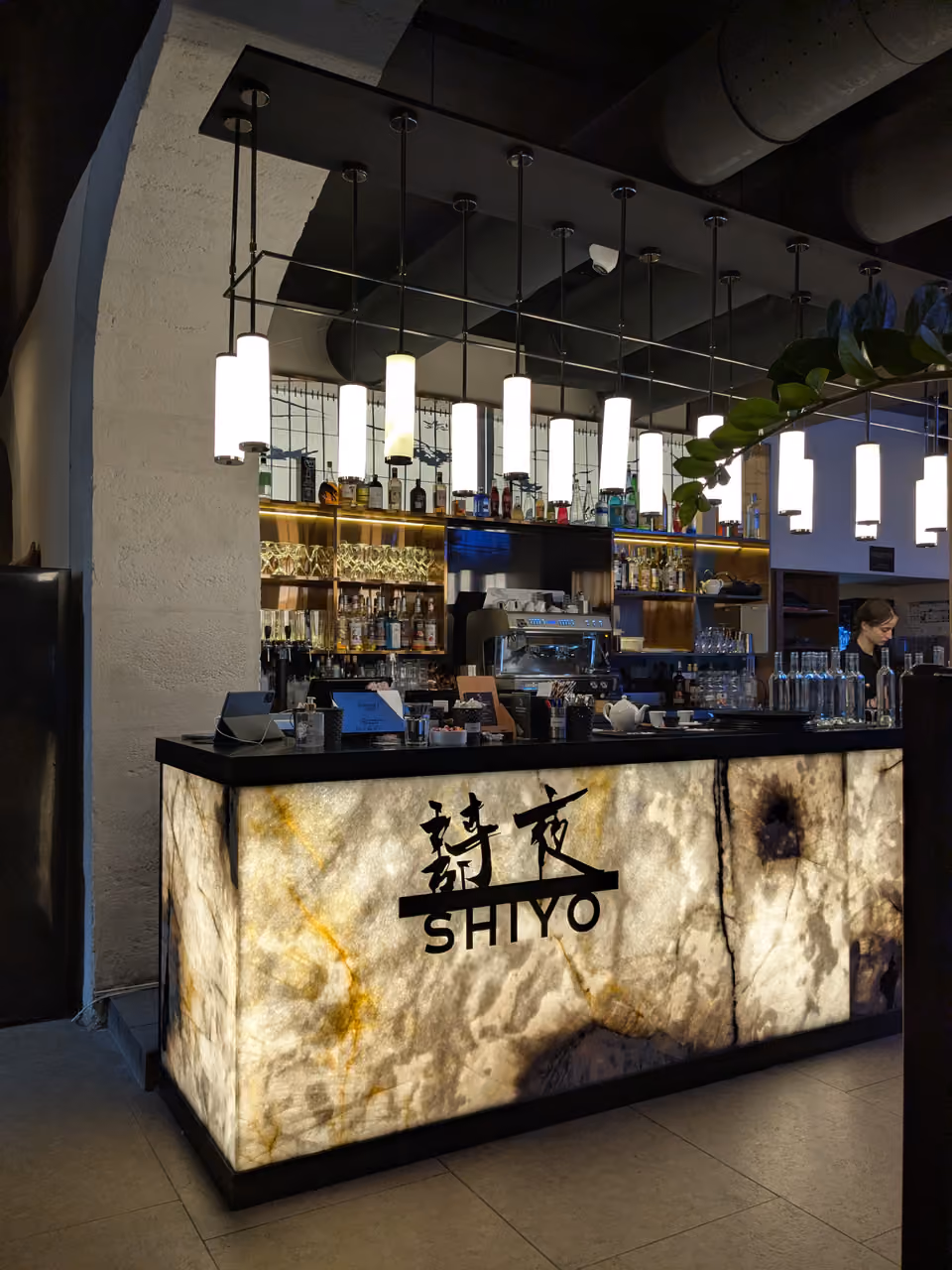 Illuminated stone bar counter at Shiyo restaurant with pendant lighting and bar stools