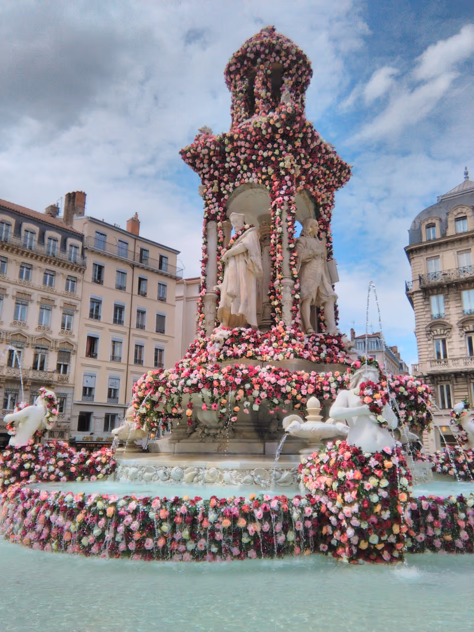The Fontaine des Jacobins decorated with pink and white roses during the Rose Festival in Lyon