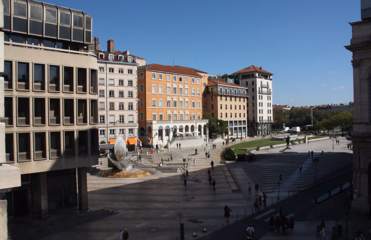 Sunny view of Place Louis Pradel and the fountain in Lyon with historical and modern buildings in the background
