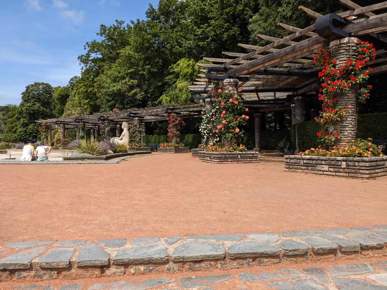Rose garden pergola at Parc de la Tête d'Or with stone pillars and climbing flowers