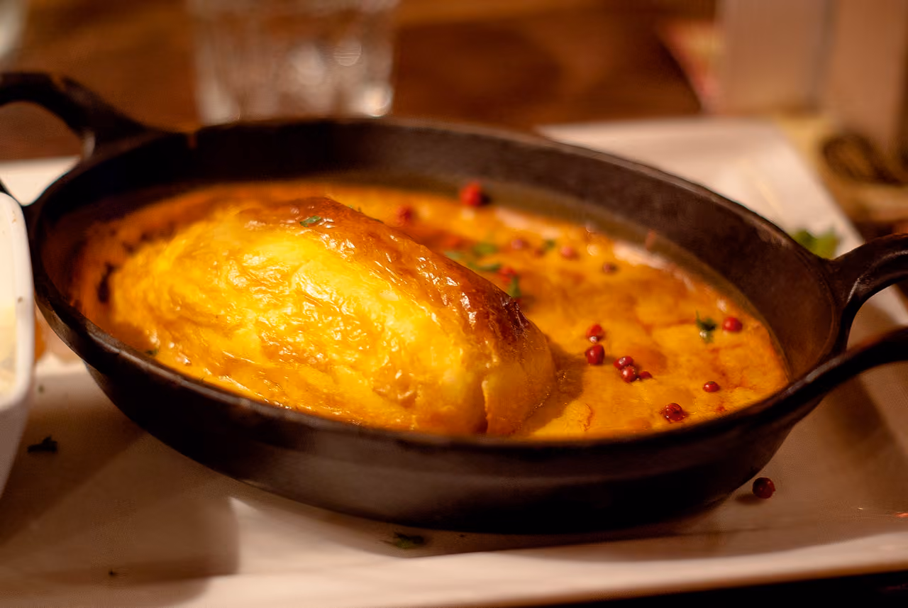 Quenelle de brochet with Nantua sauce served in a traditional cast-iron dish