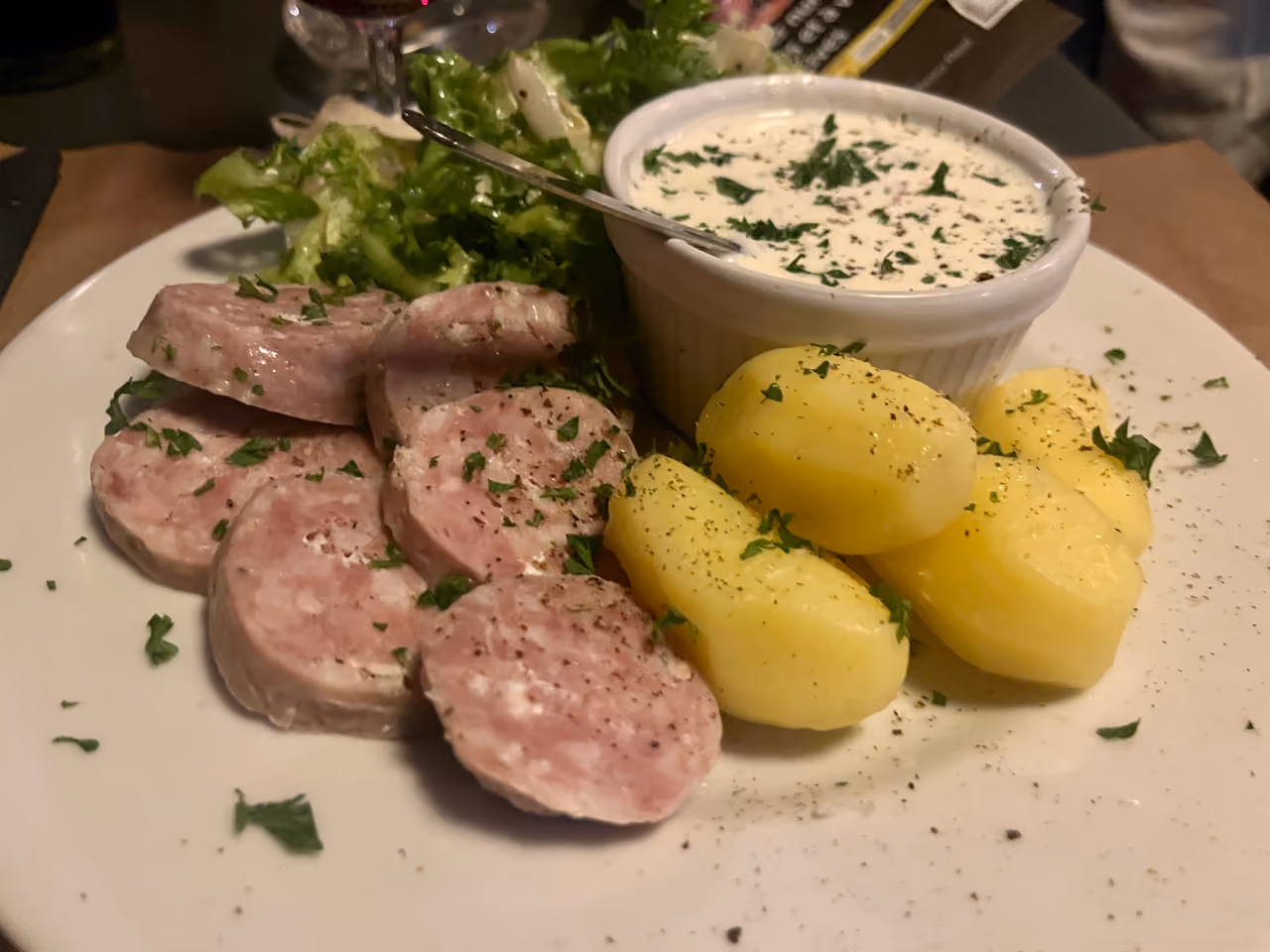 Saucisson Lyonnais sausage served with boiled potatoes, salad and cervelle de canut cheese dip