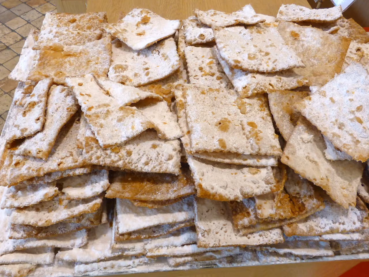 Traditional French bugnes pastries dusted with icing sugar