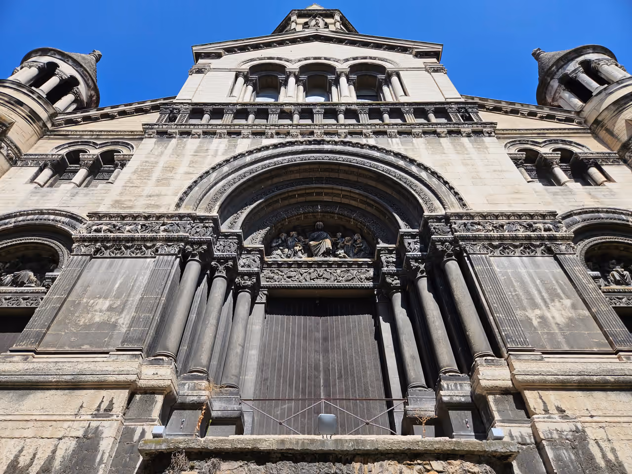 The grand Romanesque Revival facade and arched stone entrance of the Church of the Good Shepherd
