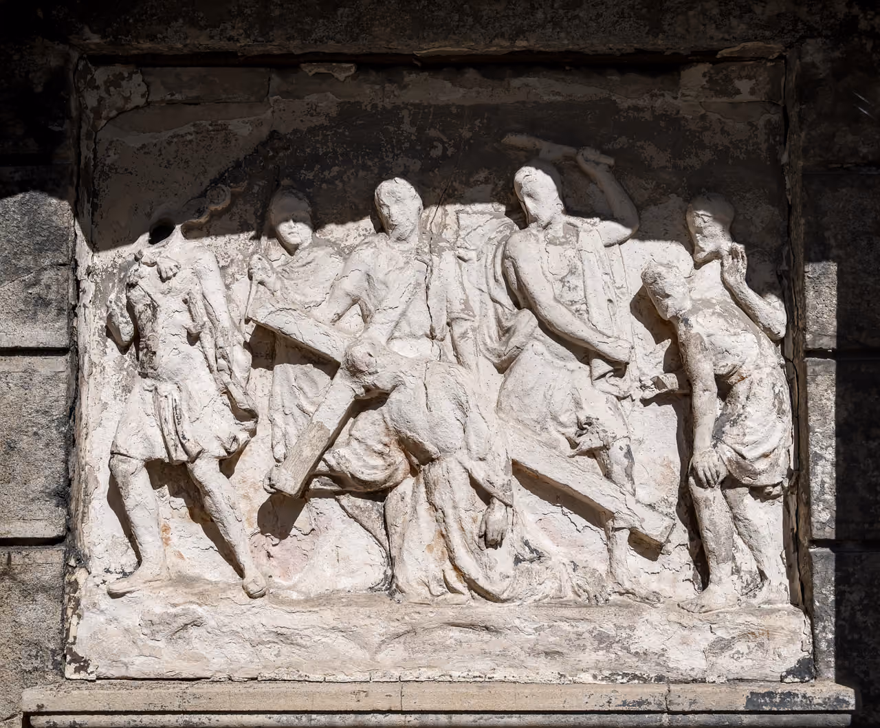 Bas-relief stone sculpture of the third Station of the Cross showing Jesus falling under the weight of the cross outside Saint-Irenee Church