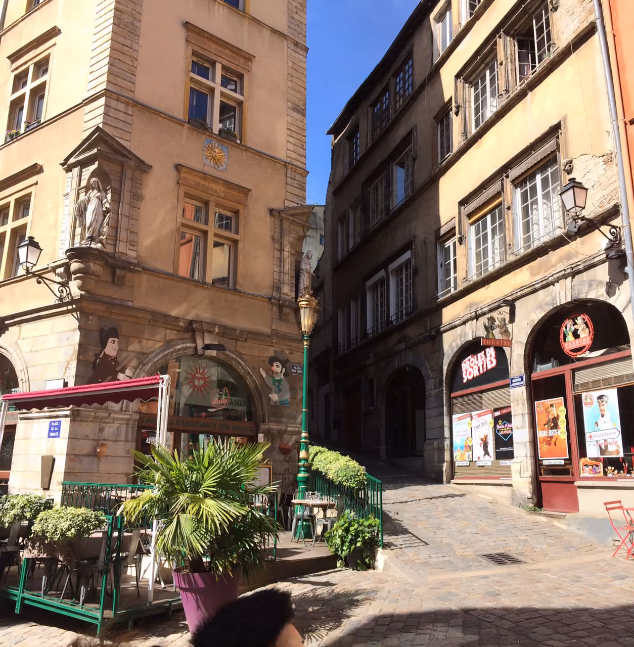 Historic cobblestone square with outdoor cafe seating and traditional European architecture