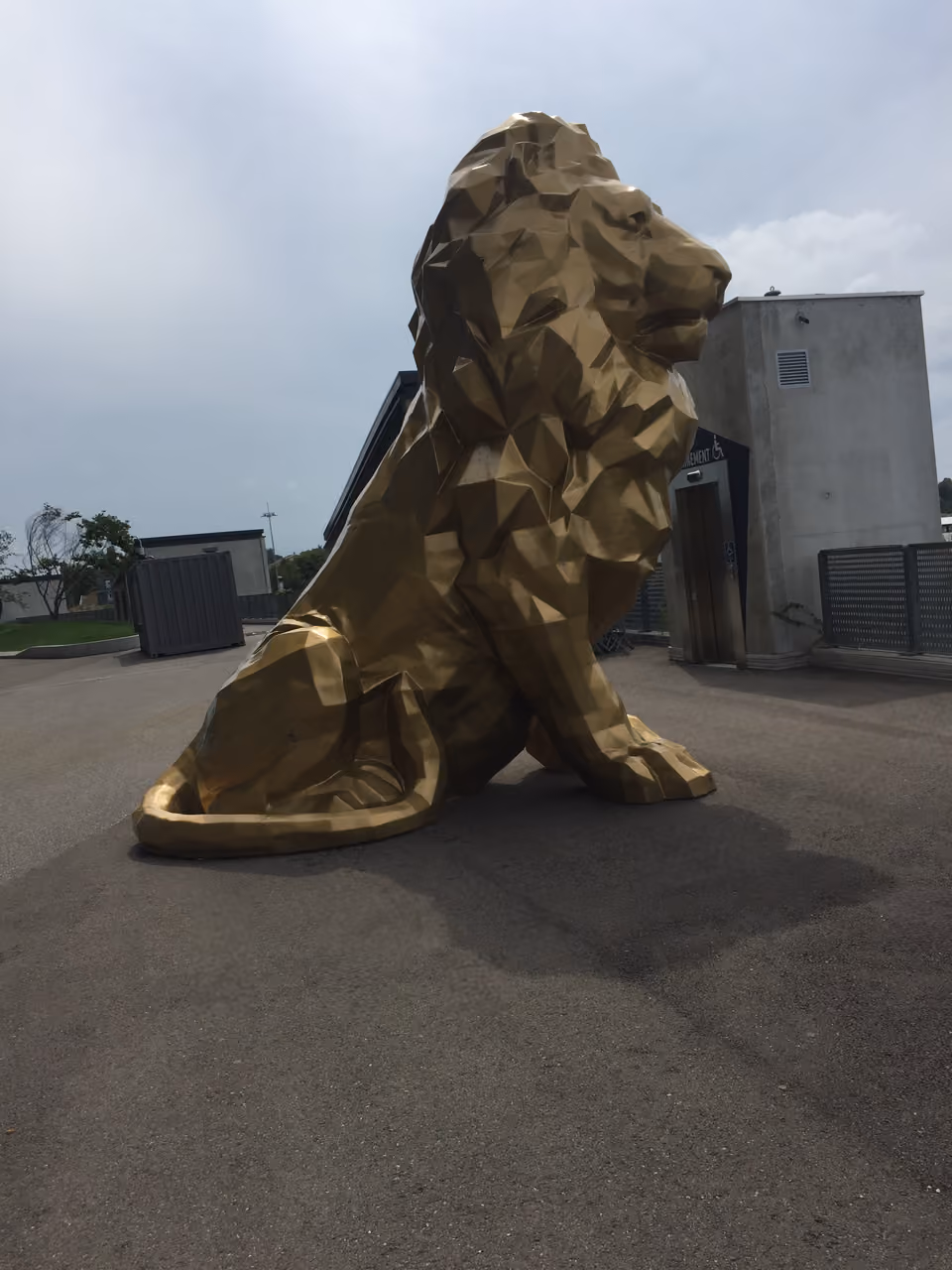 Large golden geometric lion statue outside Groupama Stadium