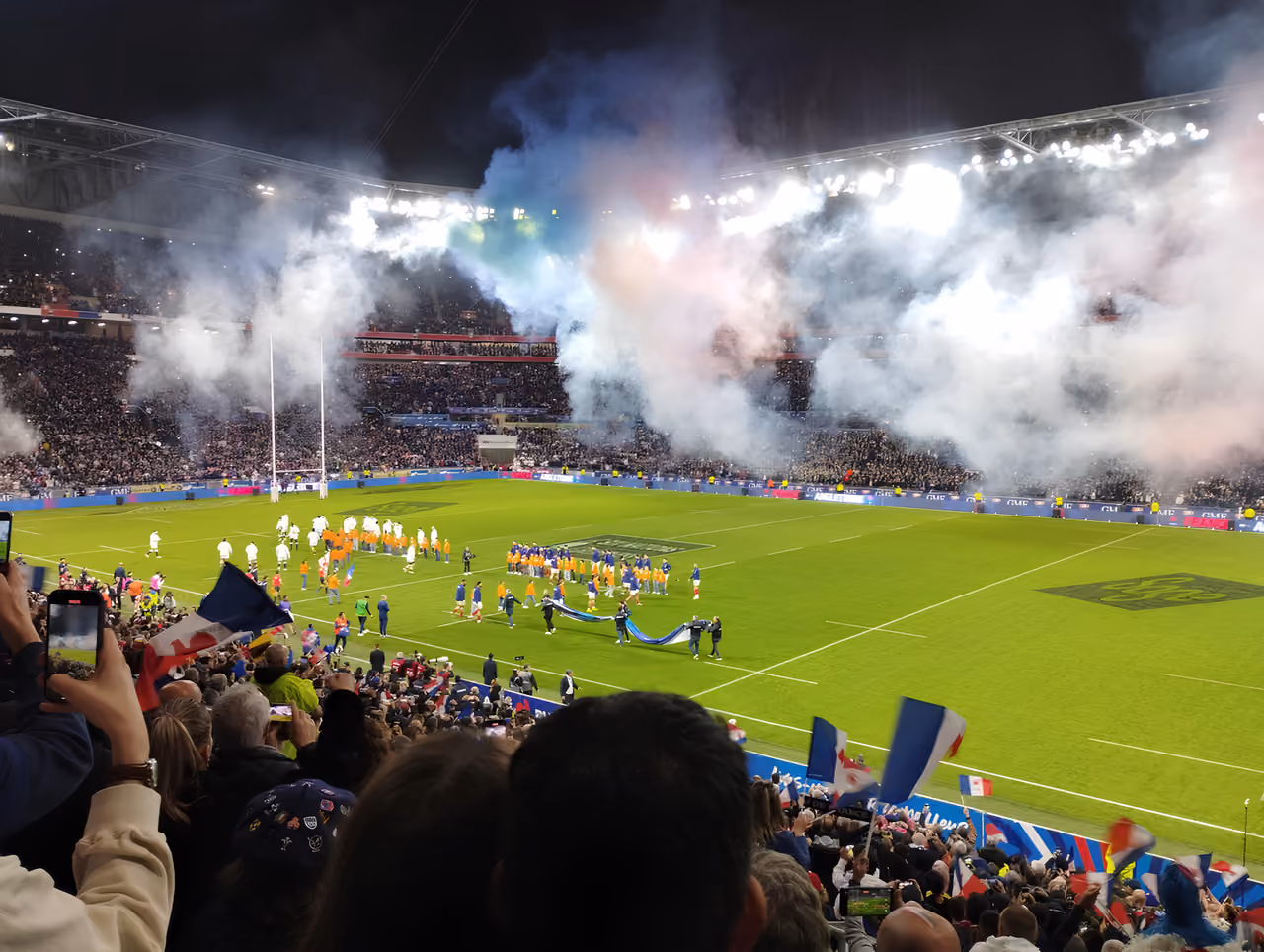 Six Nations rugby match pre-game show with smoke effects and crowds at Groupama Stadium
