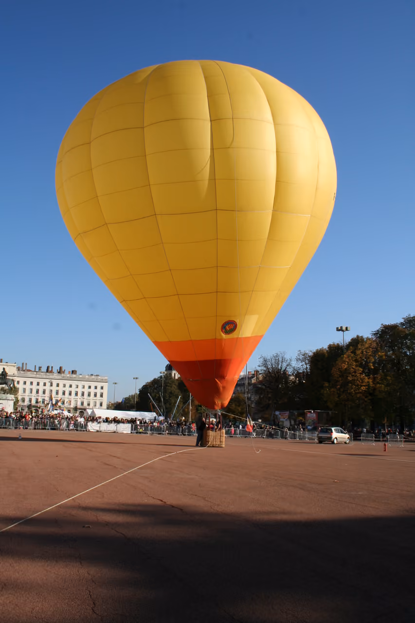 Yellow hot air balloon inflating at Place Bellecour during an event