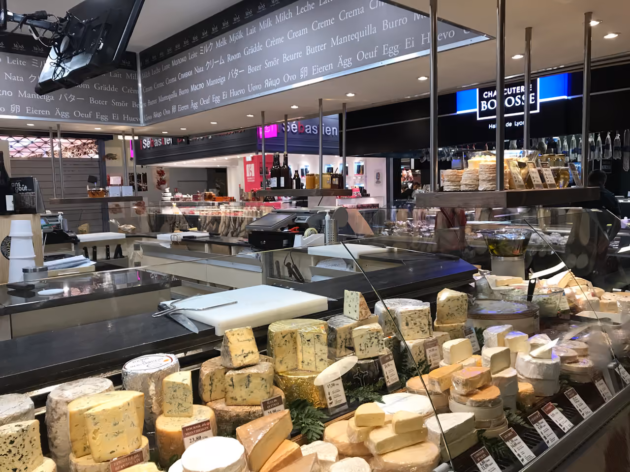 A variety of French artisanal cheeses on display at the Fromagerie Mons counter inside Les Halles de Lyon Paul Bocuse food market