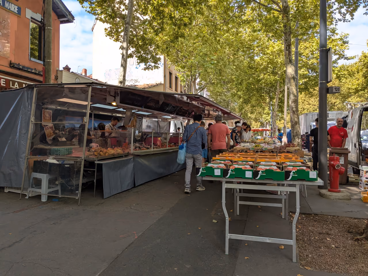 Outdoor market stalls with fresh produce and shoppers on Boulevard de la Croix-Rousse