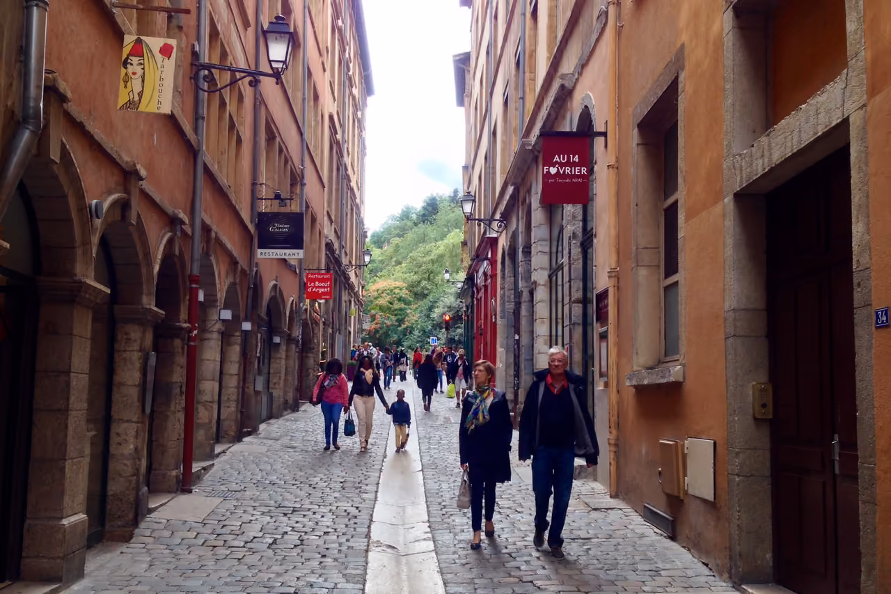 Cobblestone street in Vieux Lyon with pedestrians and historic buildings