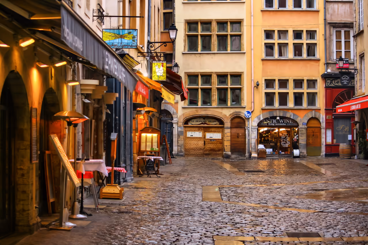 Cobblestone street in the old town district with historic buildings and outdoor restaurant seating