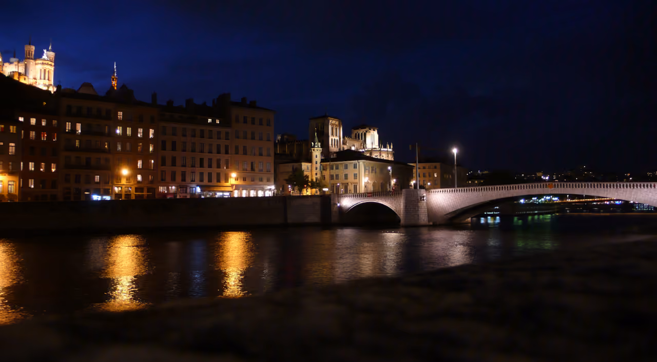 Night view of the Saone river with illuminated historic buildings and a bridge