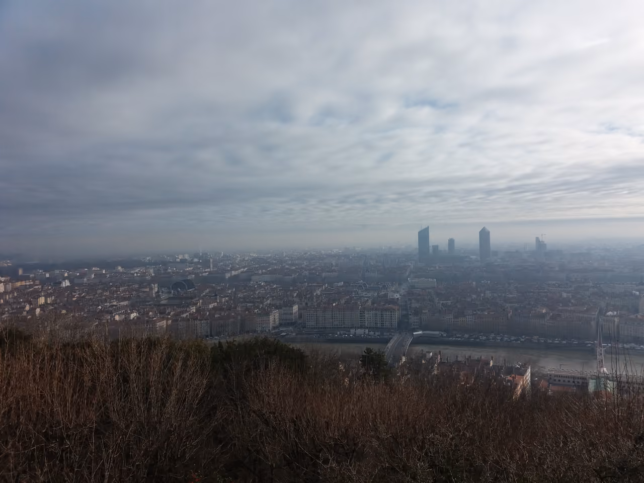 Panoramic view of a city skyline shrouded in morning mist from a high vantage point