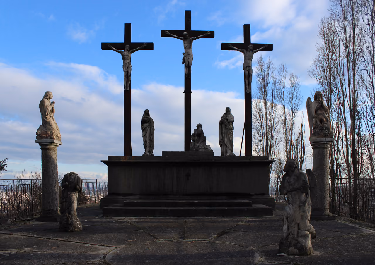 Stone Calvary monument with three crucifixes and statues at the Saint-Irenee Church