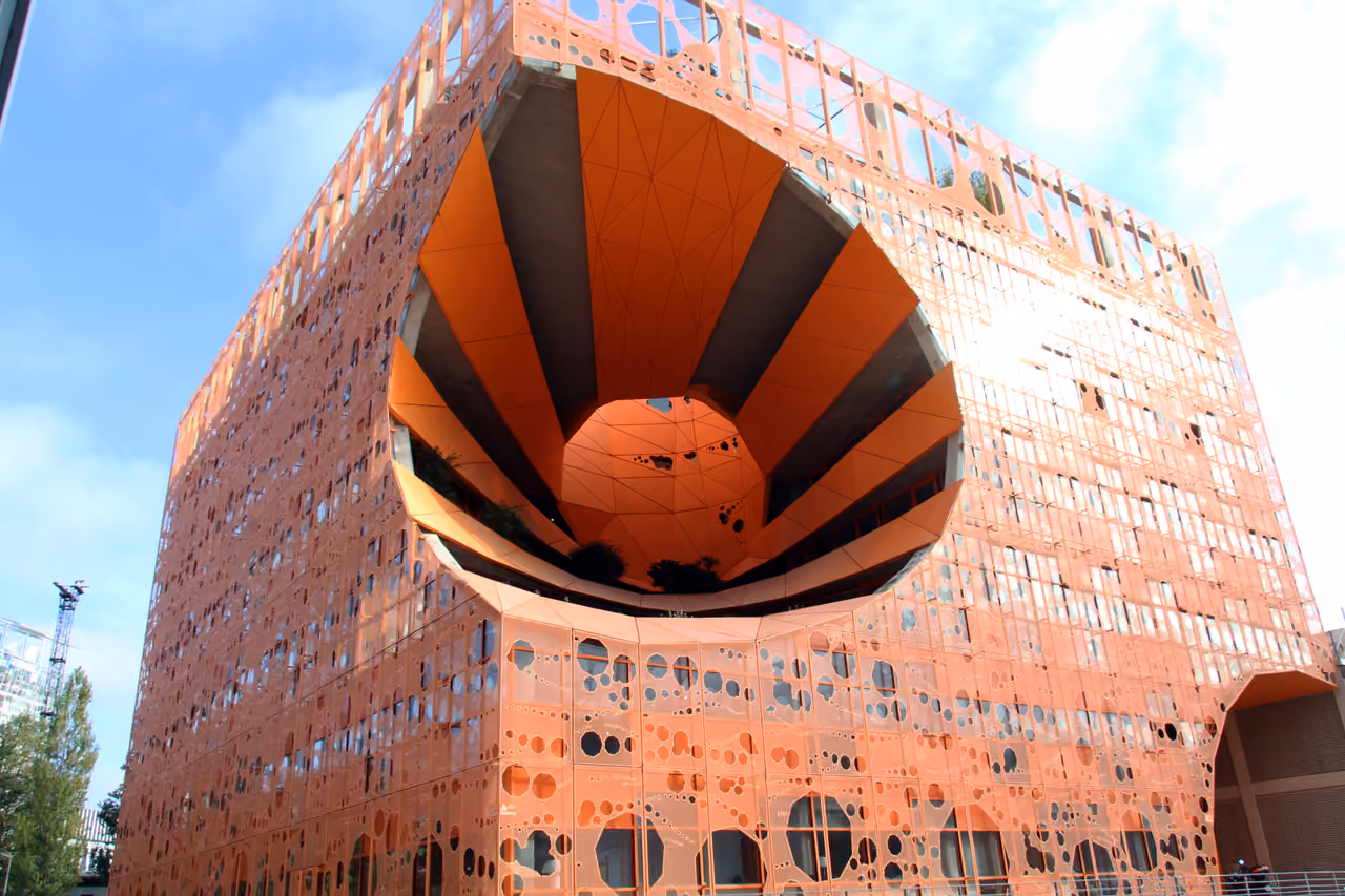 The striking orange facade and unique conical carve-out of the contemporary Orange Cube building