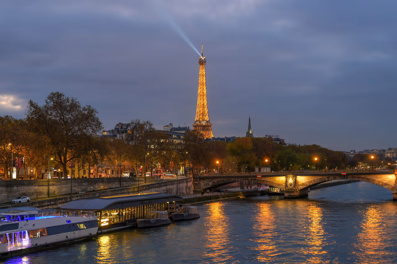Eiffel tower at night reflecting in the Seine