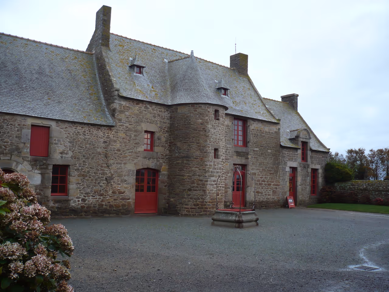Stone facade of the historic Jacques Cartier Manor House and Museum in Saint-Malo with its slate roofs and round towers