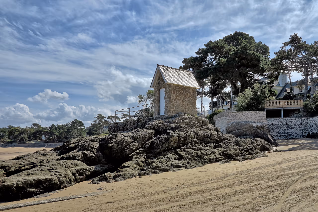 Stone guardhouse structure built on coastal rocks at the beach of Anse de Rothéneuf in Saint-Malo