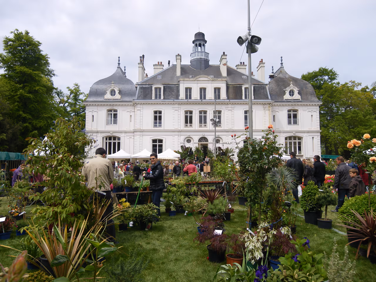 Château de la Briantais in Saint-Malo with historic architecture and a bustling flower market on the lawn
