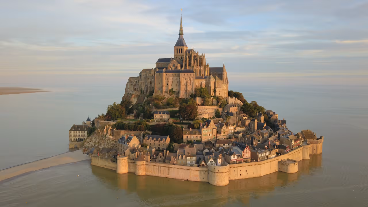 This aerial photograph captures the Mont-Saint-Michel, a tidal island in Normandy, France, topped by a medieval abbey and surrounded by a fortified wall