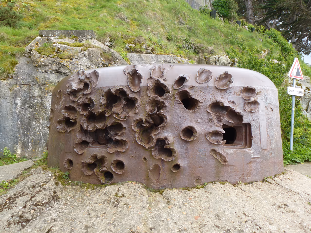 Historic stone WWII fortification bunker turret covered in shell craters and blast damage at Pointe de la Varde in Saint-Malo