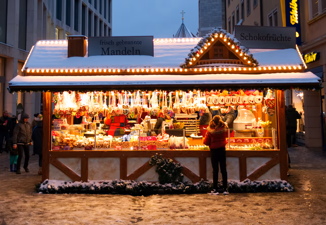 Girl buying roasted almonds at the Christmas market 