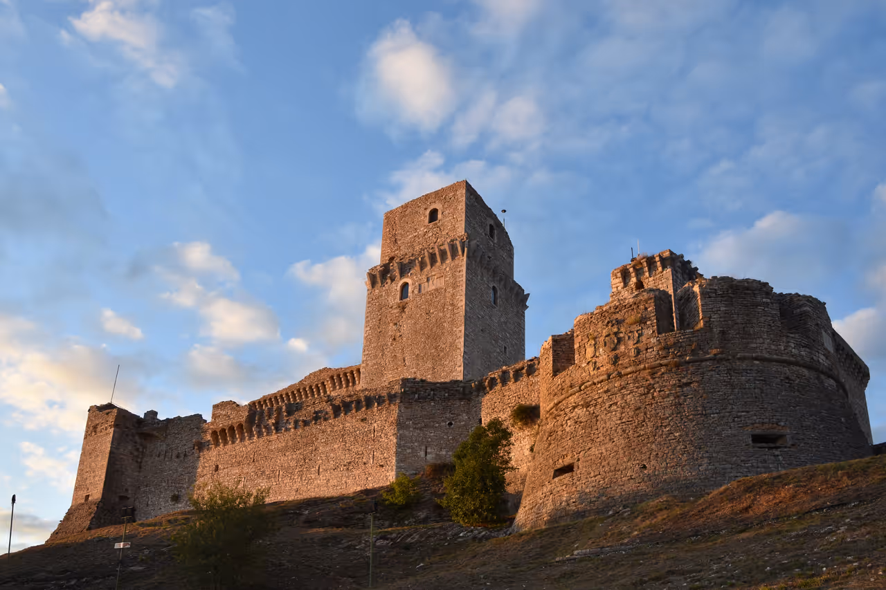 Rocca Maggiore walls and towers viewed from the south in evening light, Assisi