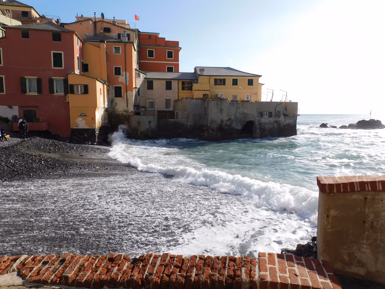 Sea paths of boccadasse in Genoa, water splashing on the beach