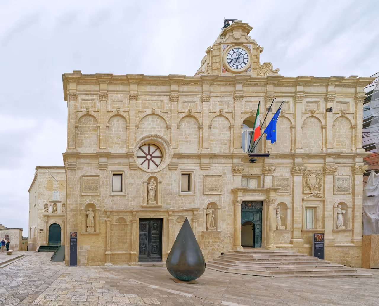 Historic buildings in Matera, with a black tear sculpture next to a building