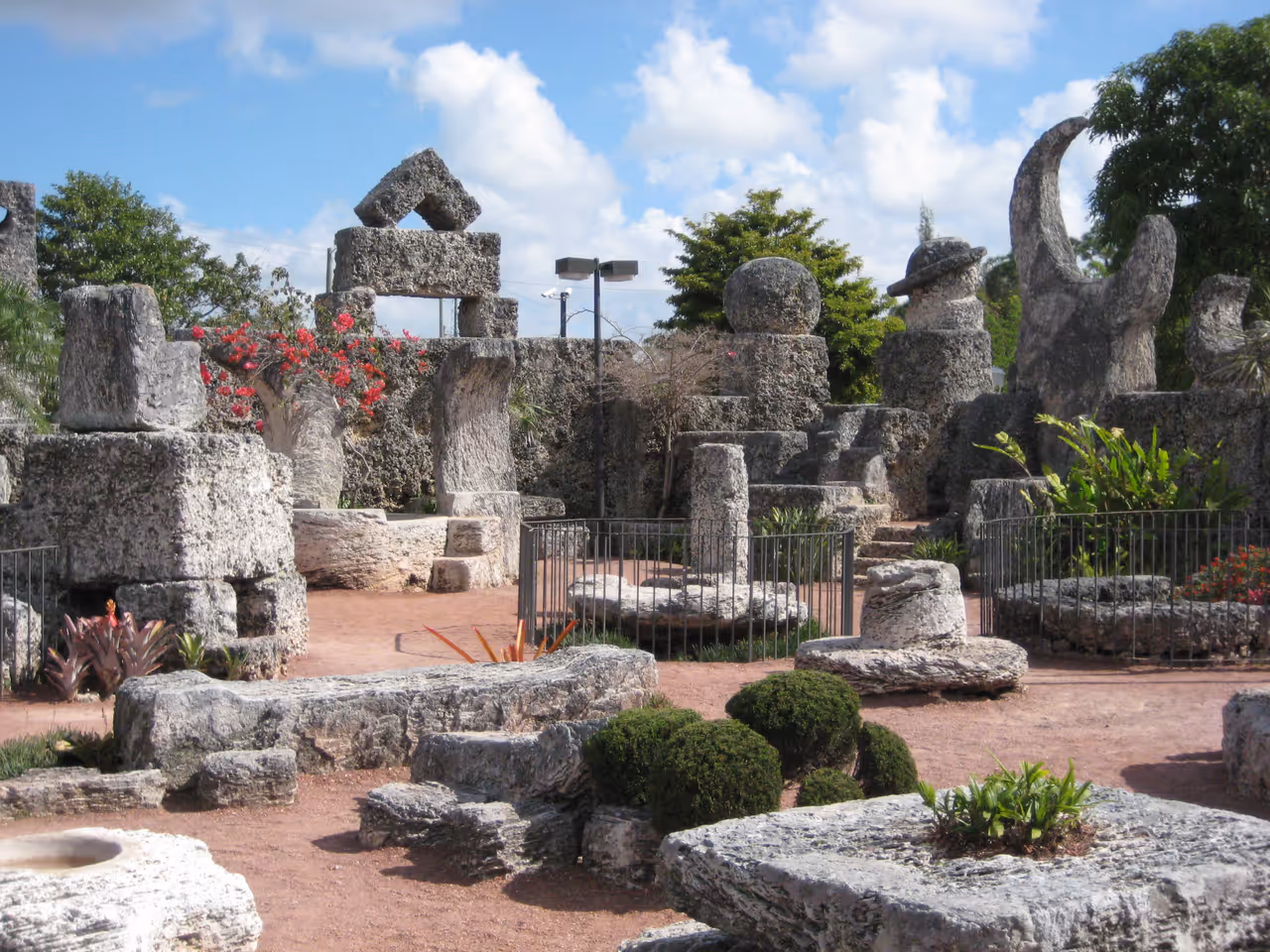 Coral Castle rock garden features large oolitic limestone sculptures under a blue sky